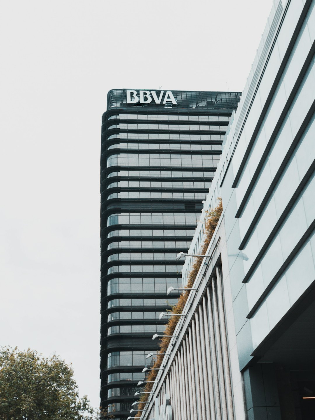 Modernas torres de oficinas con el logo de BBVA y vegetación en terrazas.
