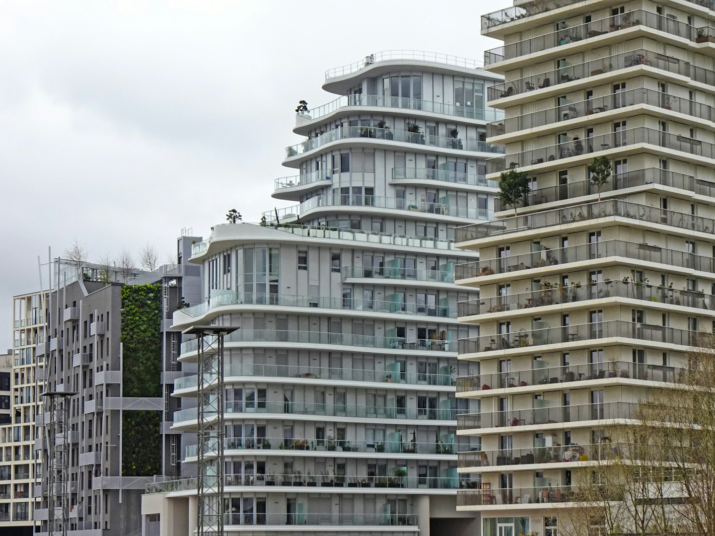 Edificios de apartamentos modernos con balcones y pared verde.