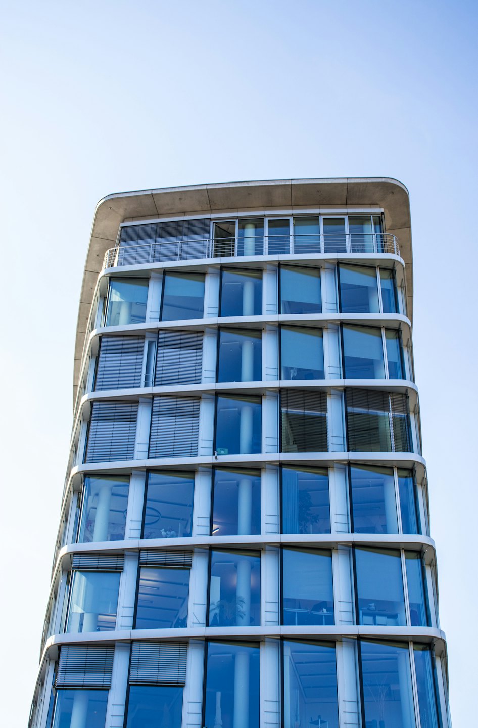 Edificio de oficinas moderno con fachada de cristal curvada.